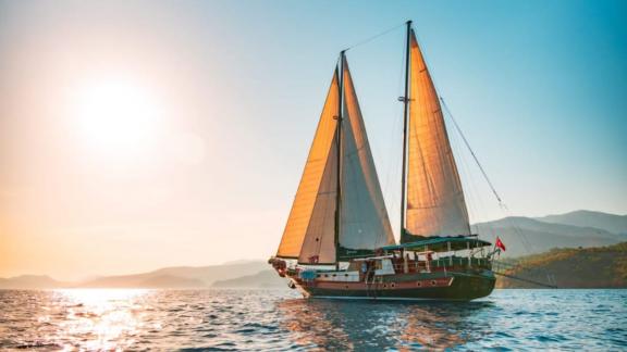 Die Gulet Peri segelt bei Sonnenuntergang auf dem ruhigen Meer vor Marmaris.